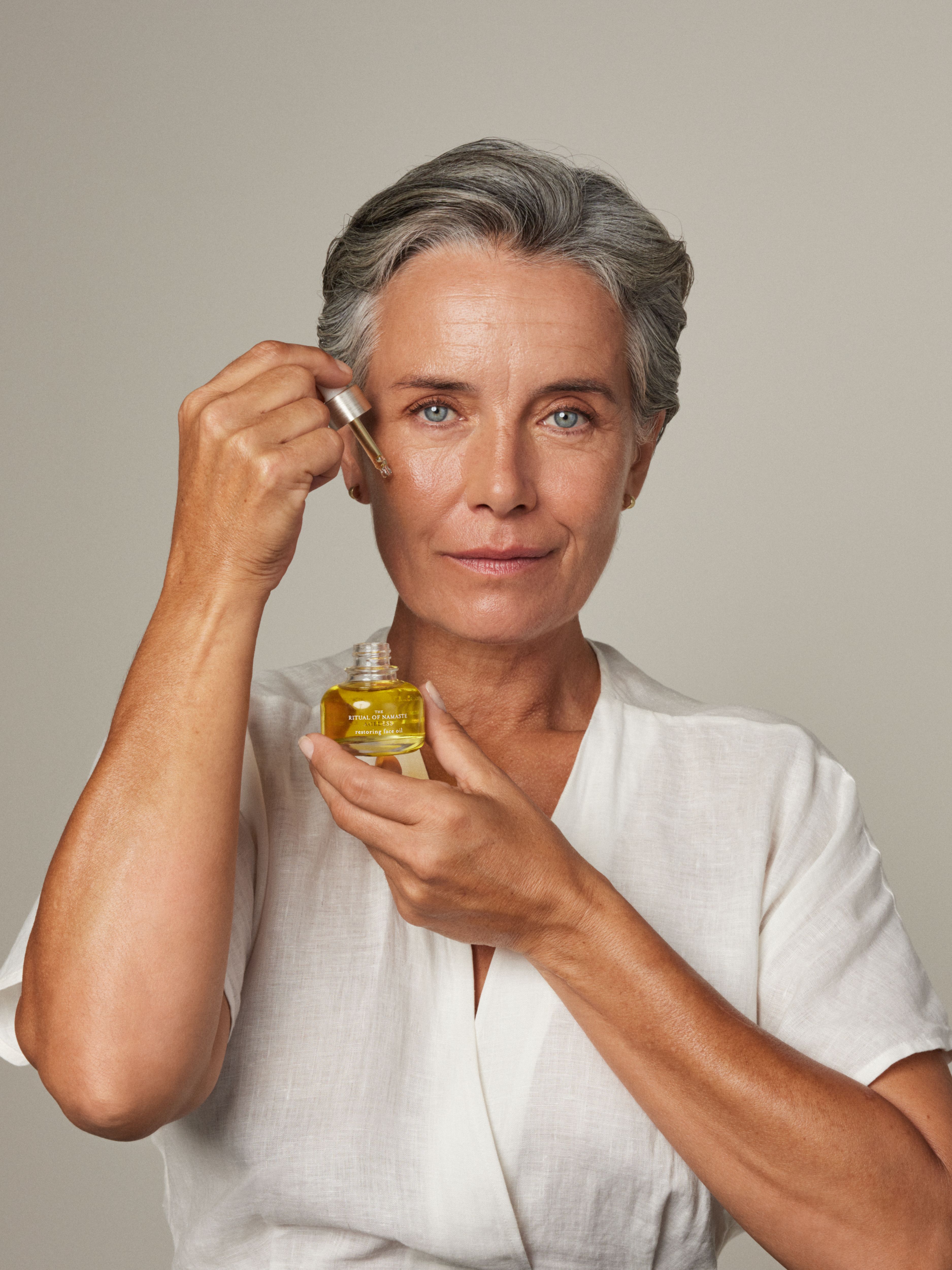 The Ritual of Namaste Restoring Face Oil Studio with Model and Product