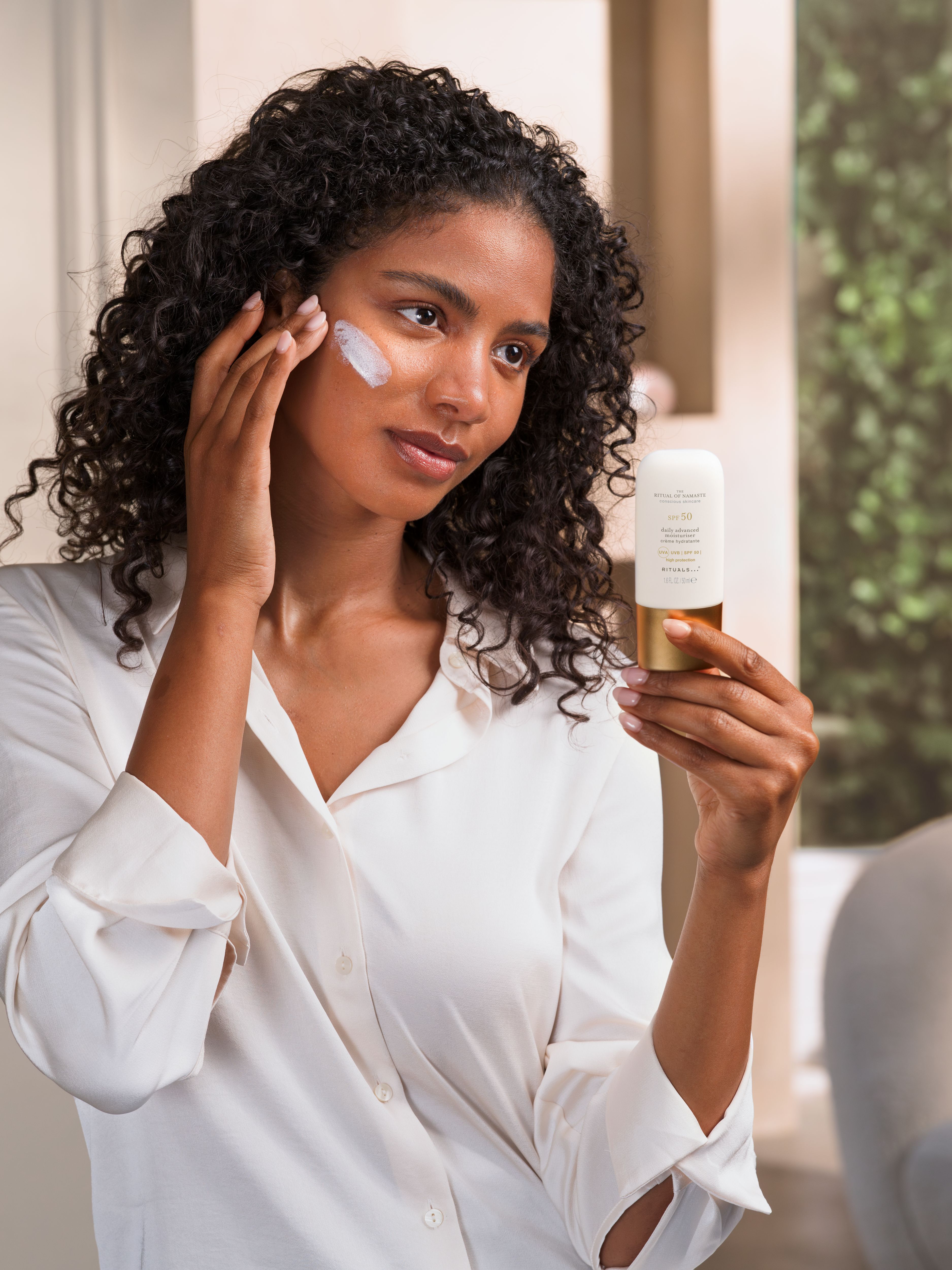 The Ritual of Namaste SPF 50 Daily Advanced Moisturiser Studio with Model and Product